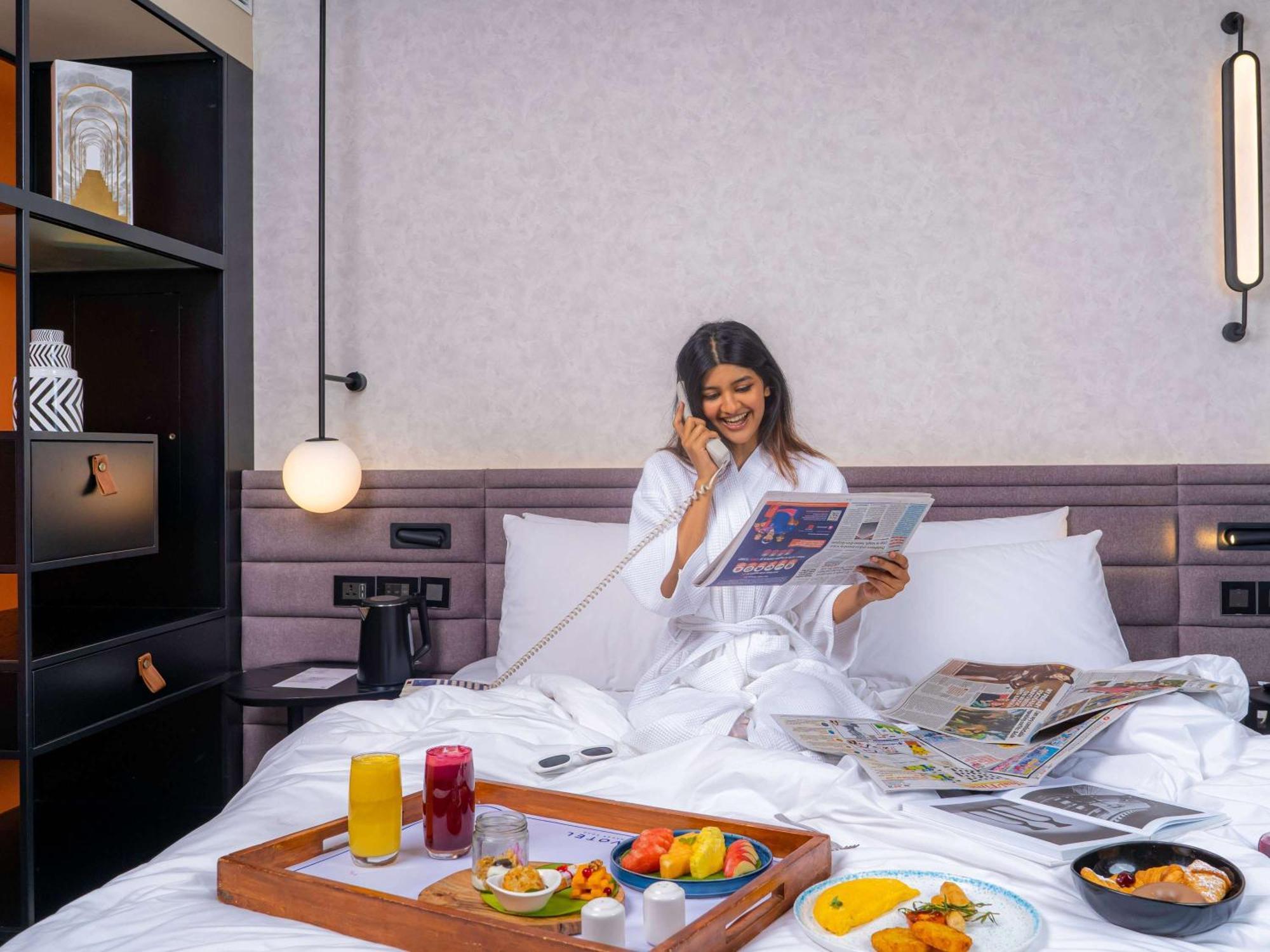 Novotel Pune Viman Nagar Road Exterior photo A woman enjoying room service at a hotel